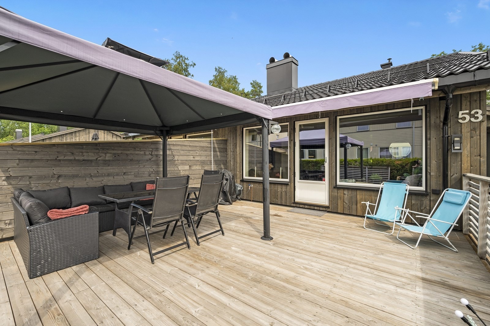 Terrassen er solrik og skjermet, og har både terrassemarkise og pergola Galleribilde