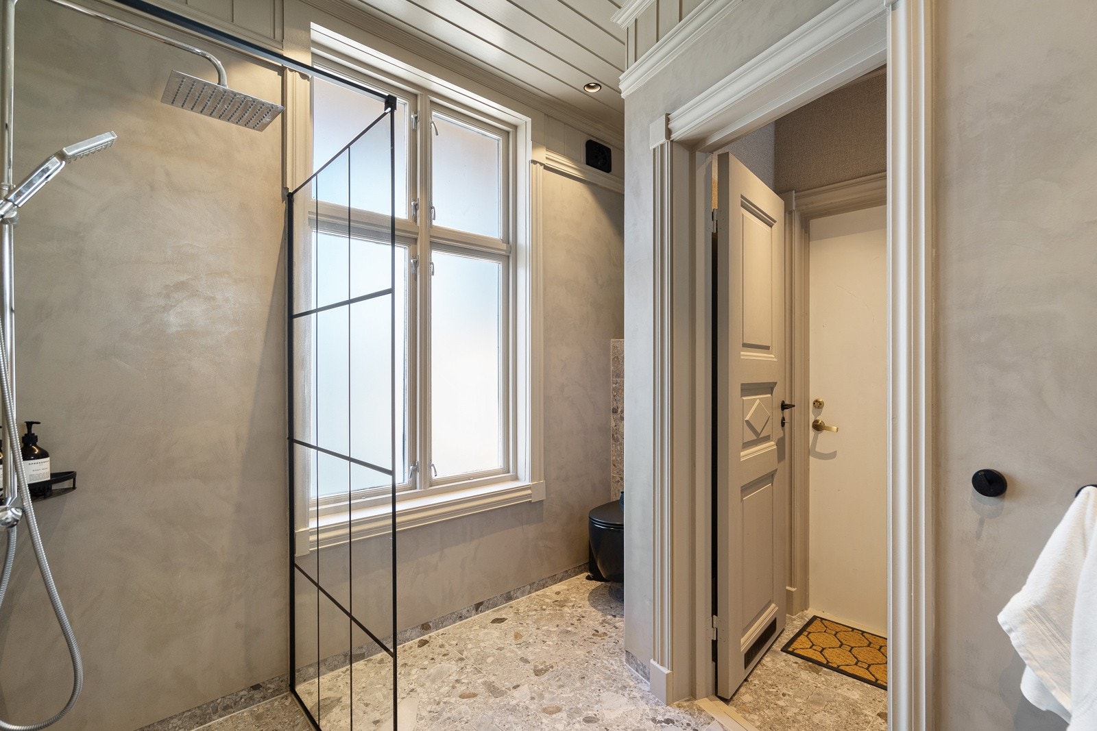 Her er det brukt mikrosement på vegger, fliser på gulv og panel i taket - en lekker og tidstypisk kombinasjon. Galleribilde