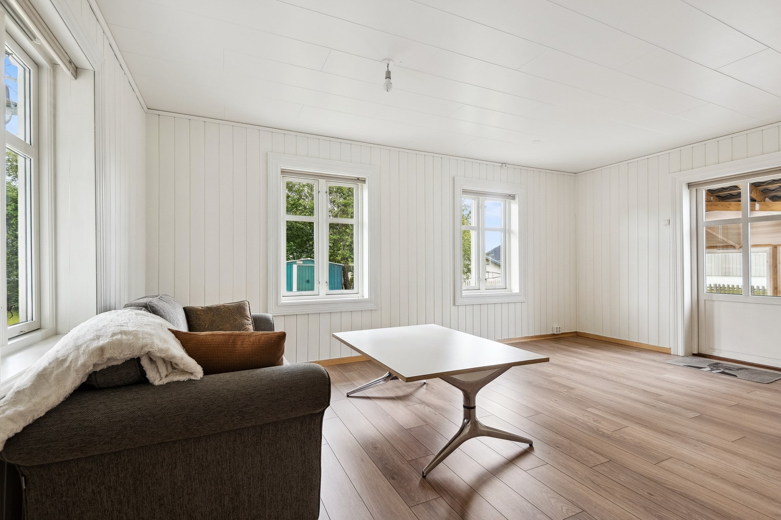 Stue med store vindusflater og god plass for både sofagruppe og tv-møblement Galleribilde