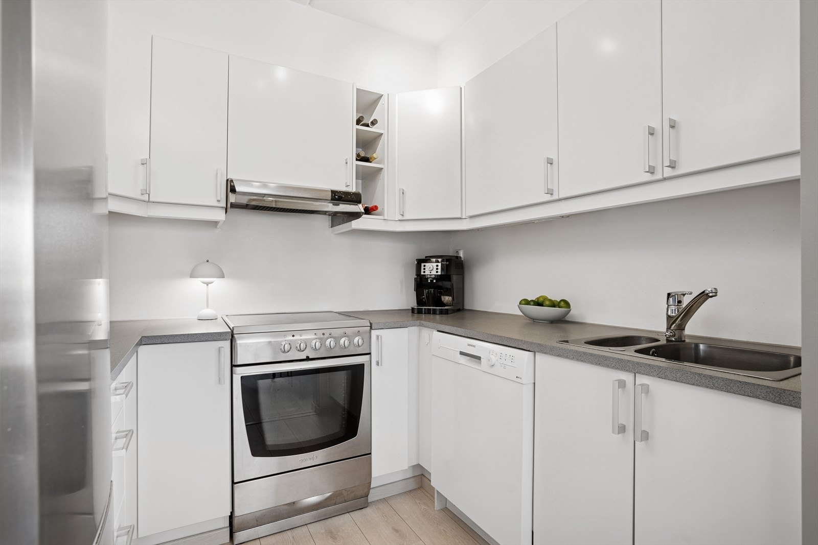 Kjøkkenet er utstyrt med glatte fronter og en benkeplate i laminat, samt oppvaskmaskin og komfyr. Galleribilde