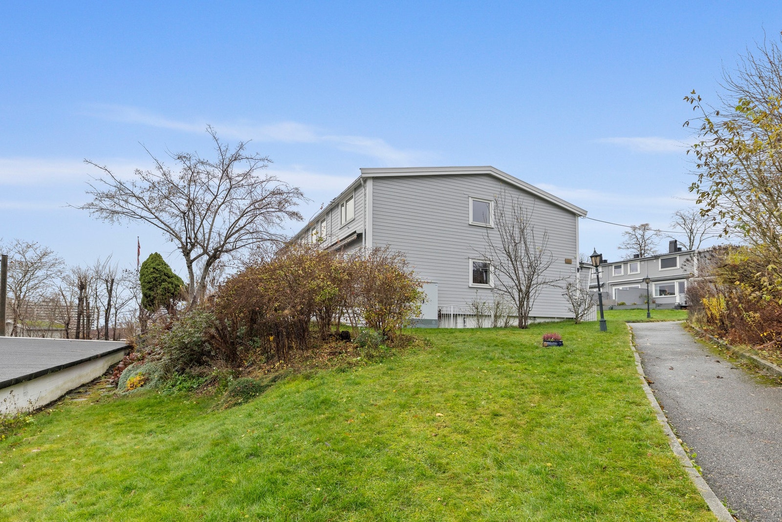 Felleseiendommen har store plenarealer, rikelig med prydbusker og trær, samt lekeapparater, felles utemøbler og asfalterte internveier Galleribilde