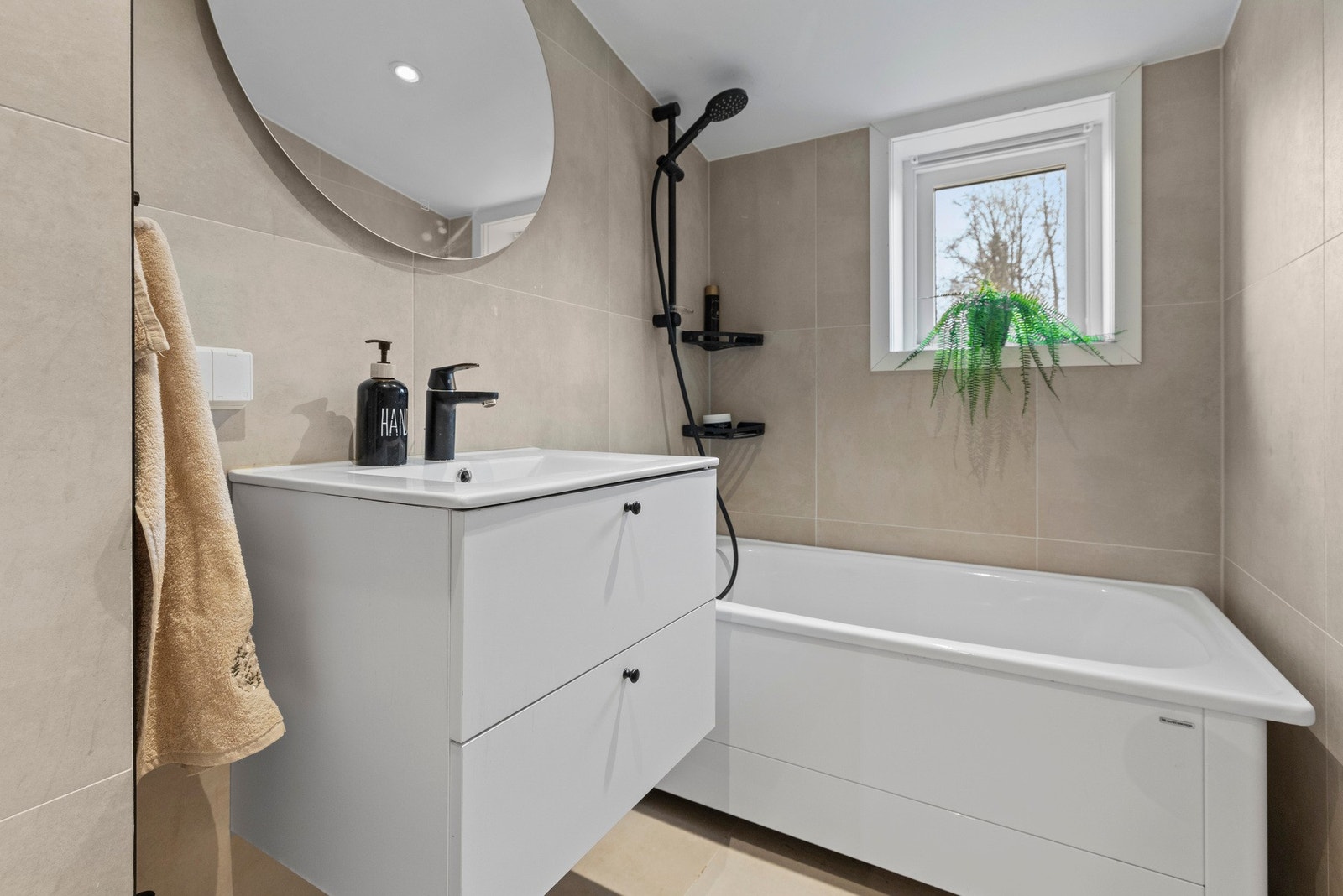 Badet har flislagte vegger og gulv med gulvvarme, samt slette overflater i himlingen med innfelte downlights Galleribilde