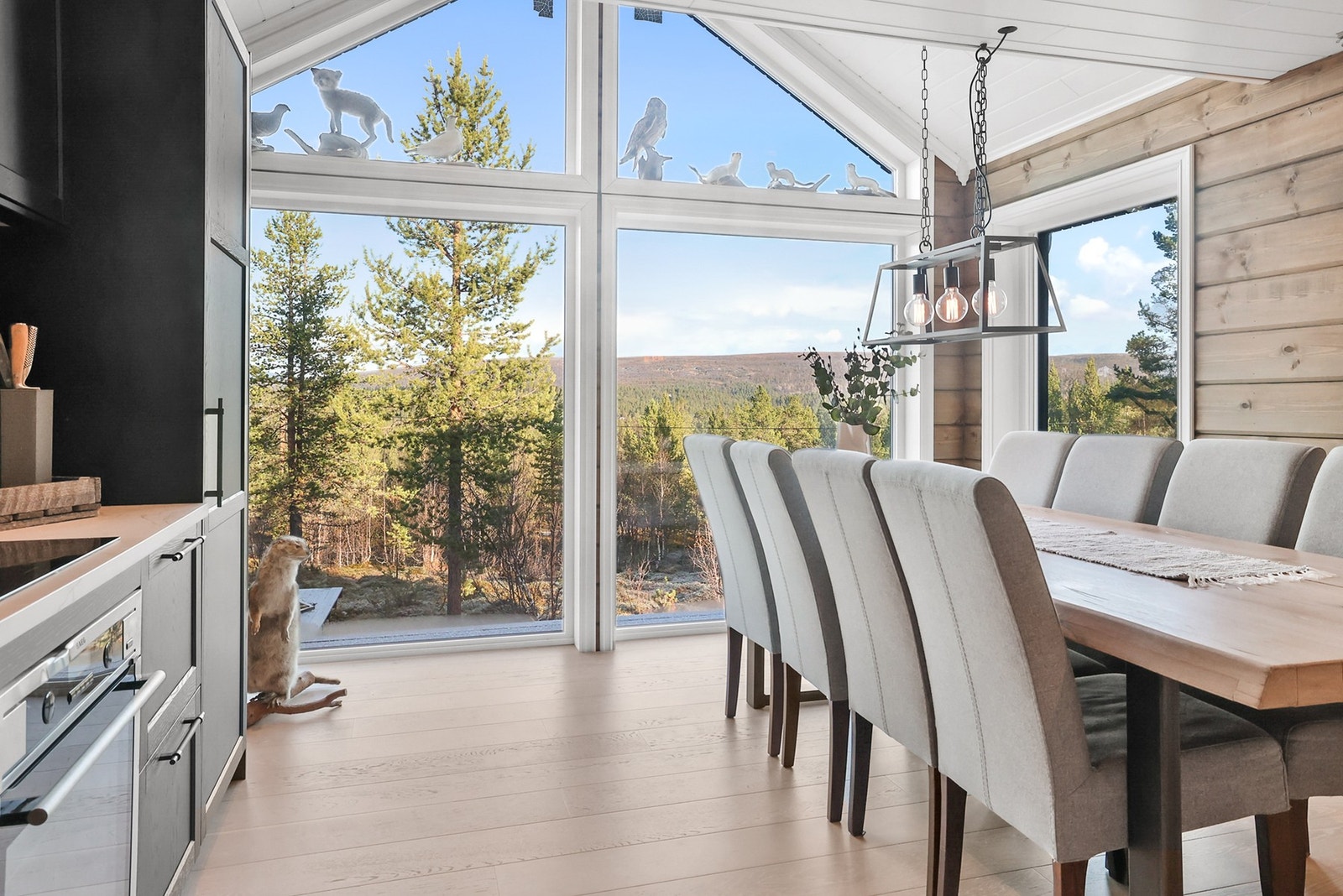 Kjøkken med store vinduer som gir bra med naturlig lys inn til rommet Galleribilde