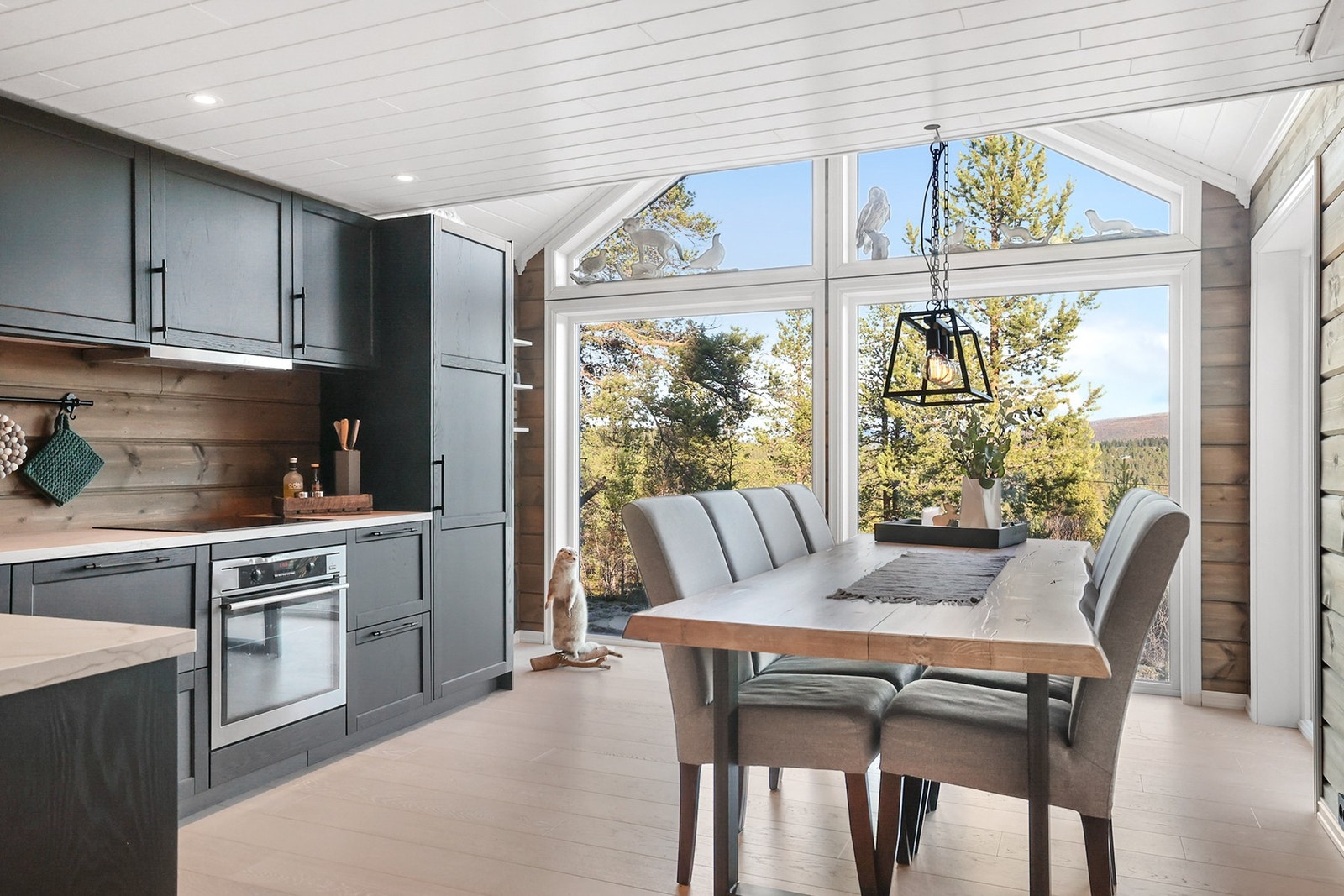 Kjøkken med store vinduer som gir bra med naturlig lys inn til rommet Galleribilde