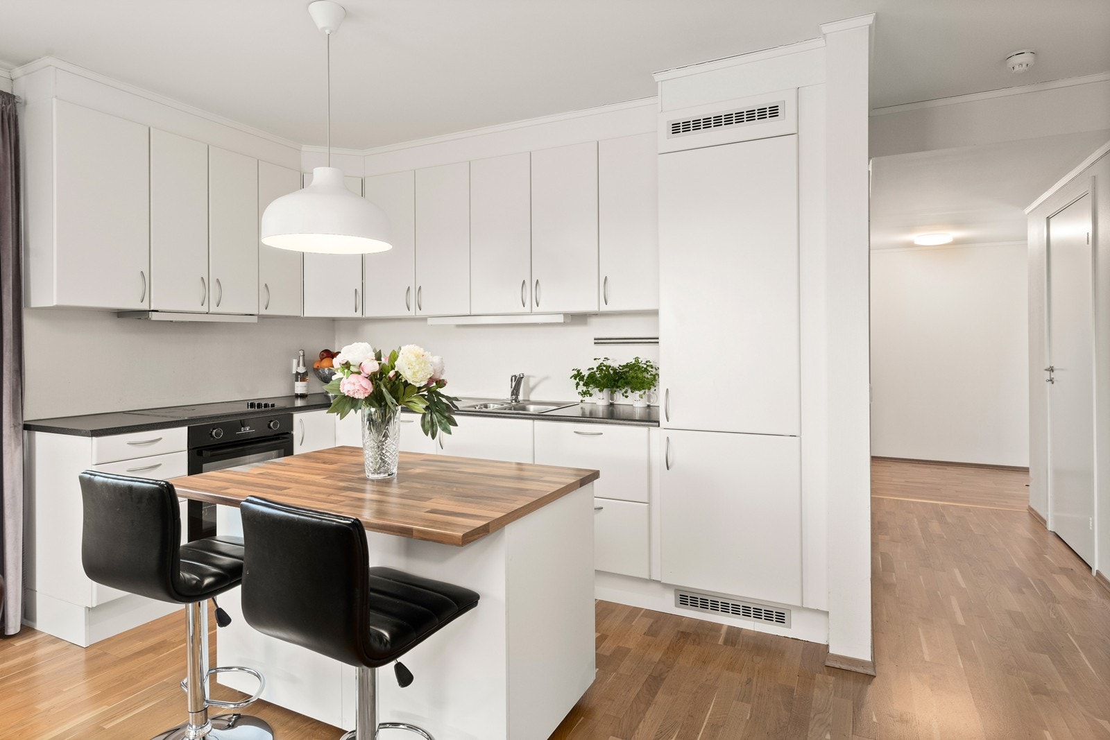 Når du kommer inn i leiligheten, møtes du av en romslig entré med god plass til yttertøy og sko i et praktisk garderobeskap. En mellomgang leder deg videre til de ulike rommene i boligen. Galleribilde