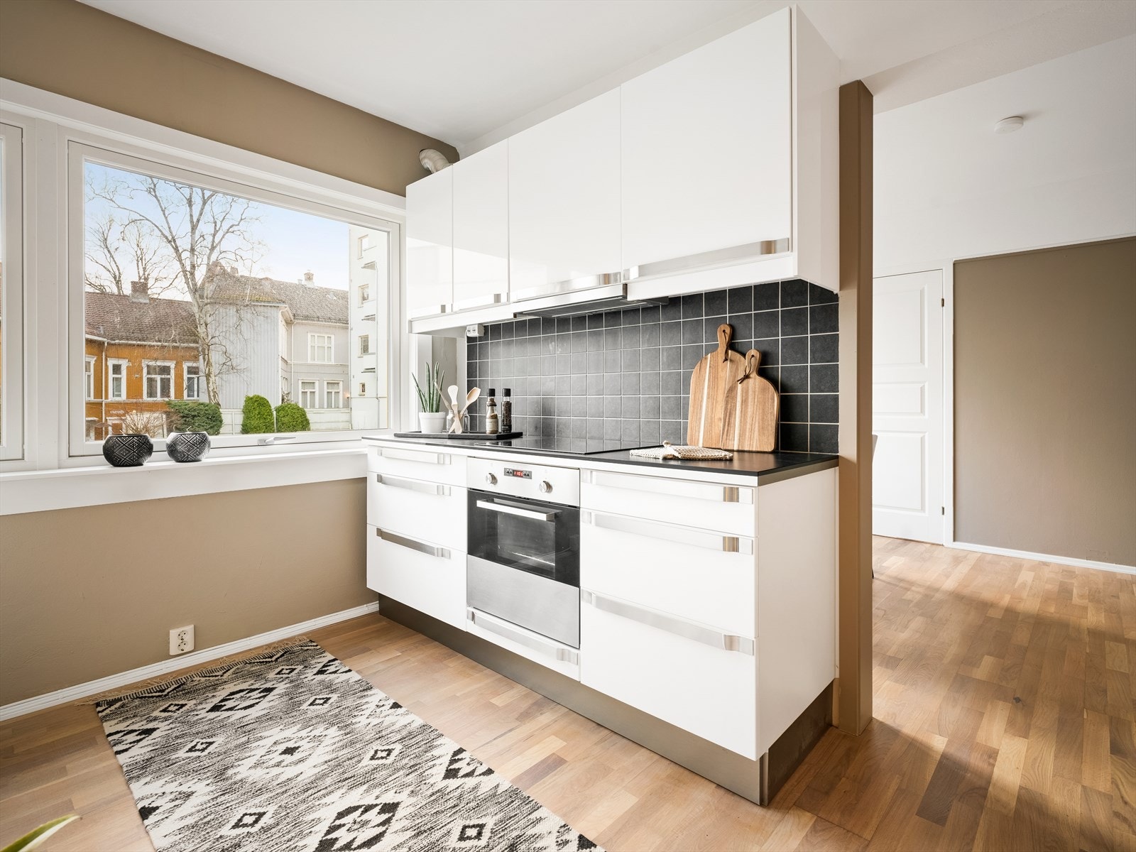 Kjøkkenet har integrerte hvitevarer som komfyr, platetopp og oppvaskmaskin Galleribilde