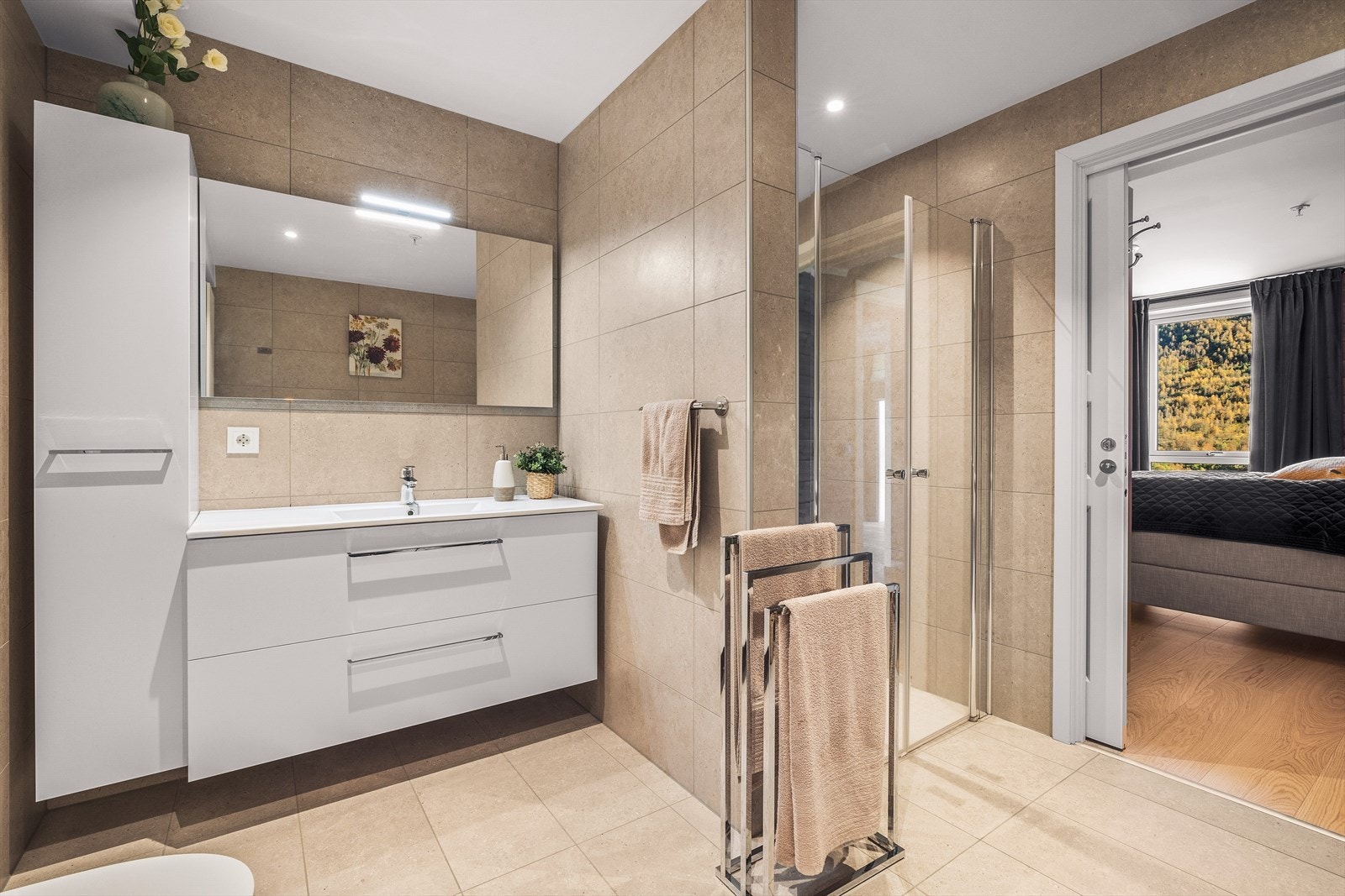 Rommet er ellers utstyrt med dusjnisje, vegghengt toalett, helstøpt servant med skuffer og høyskap. Galleribilde