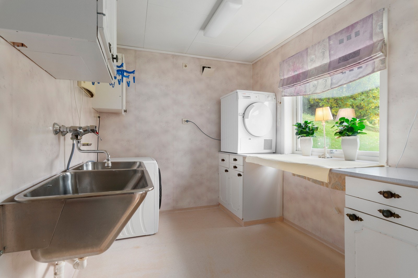 Vaskerommet er utstyrt med en dobbel stålvask, sluk og opplegg for vaskemaskin og tørketrommel. Galleribilde