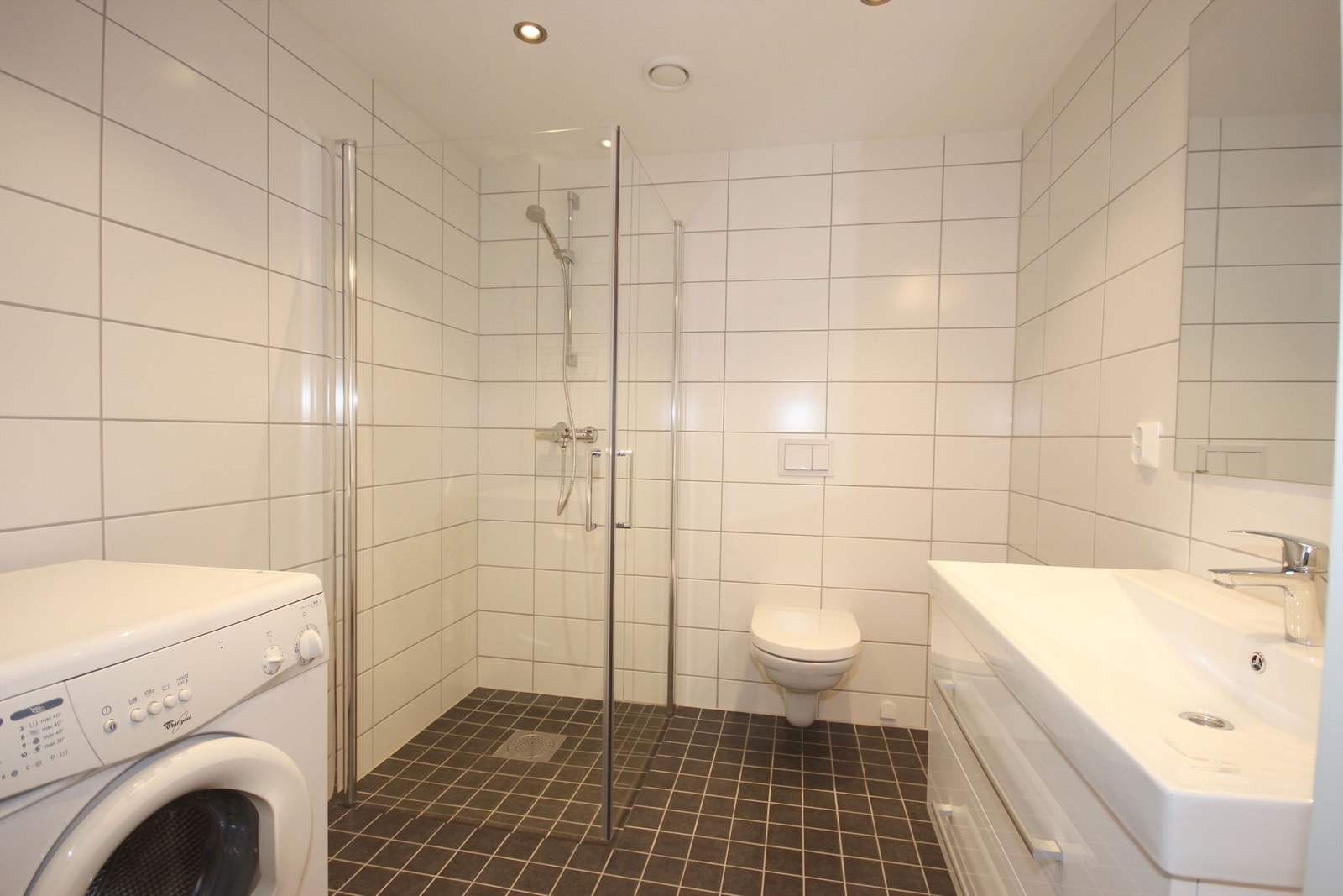 Pent flislagt bad med vaskemasin. Galleribilde