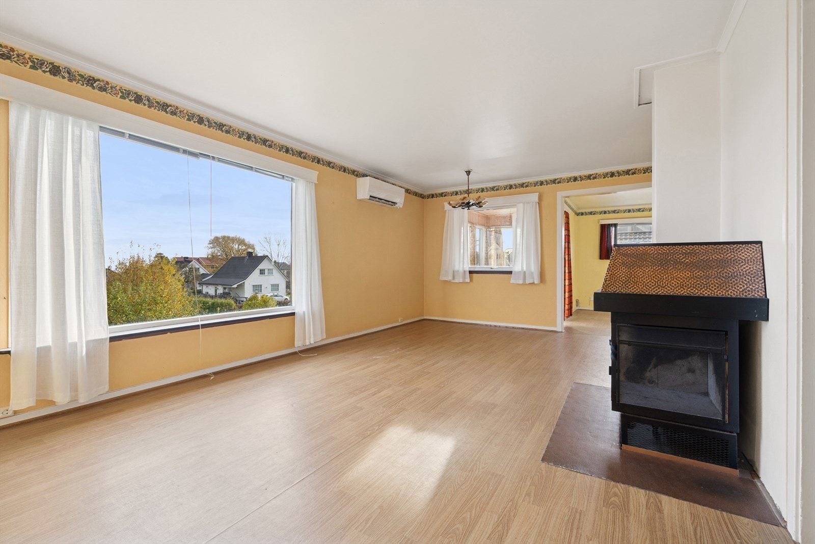 Store vindusflater gir godt lysinnslipp i stuen, som har laminatgulv og vedovn. Galleribilde