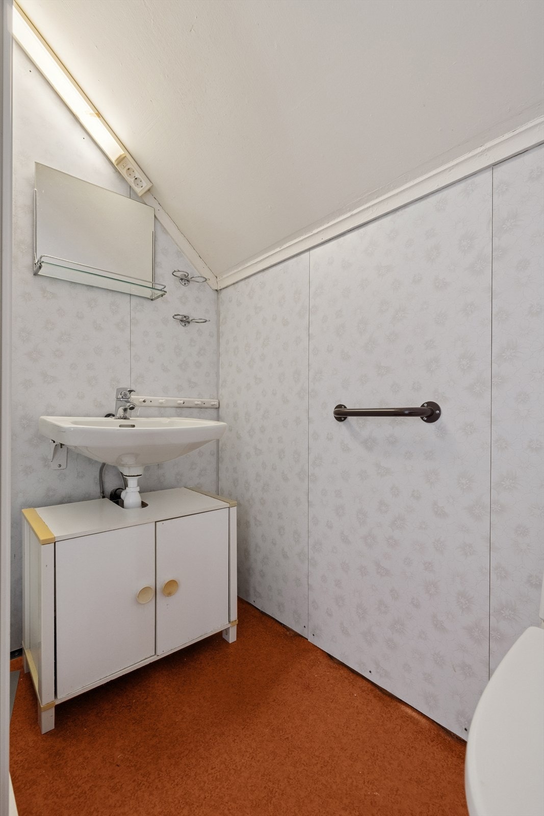 Eldre bad med gulv av betong, delvis belagt med vinylbelegg og elektriske varmekabler. Galleribilde