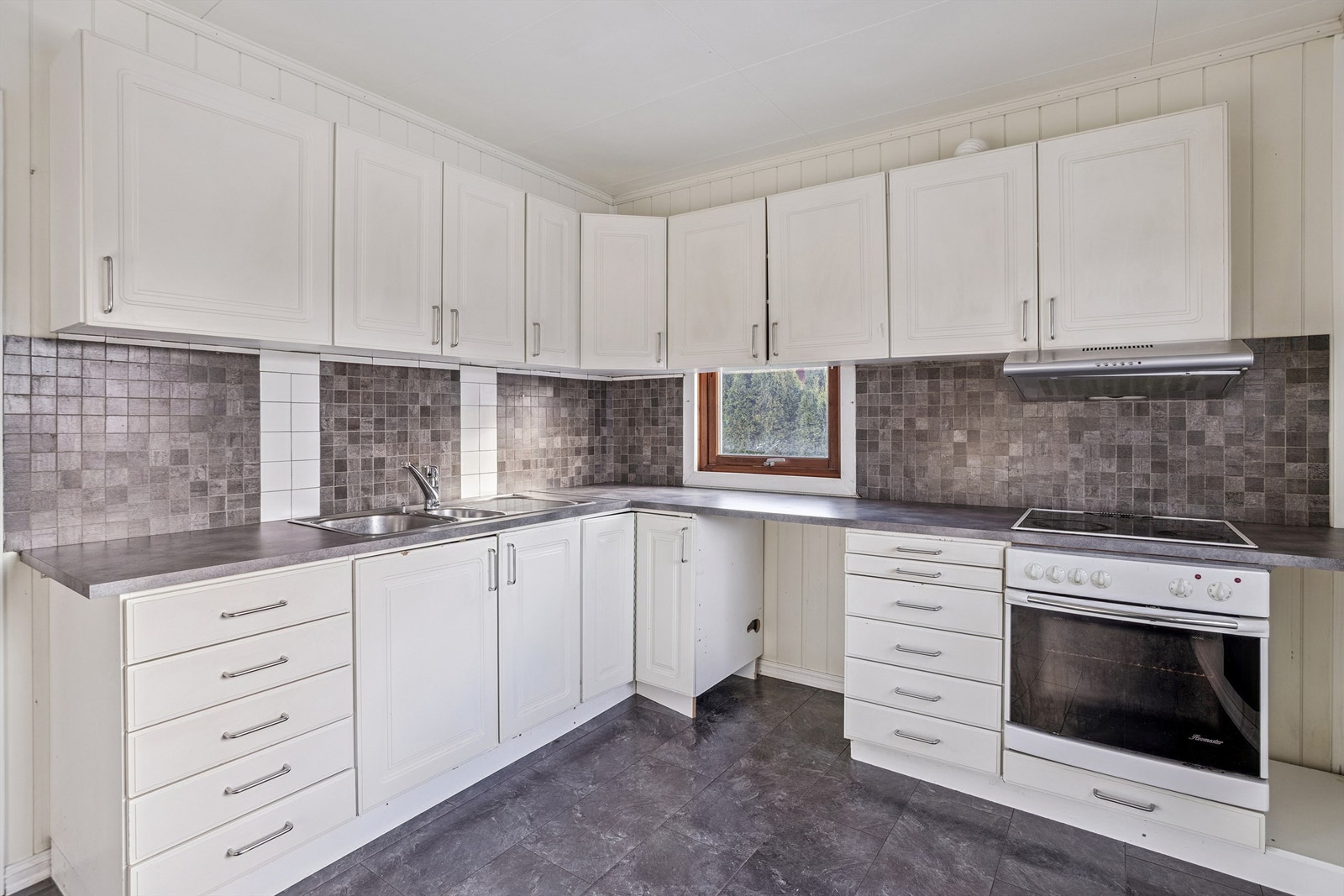 Innredningen har profilerte fronter og laminat benkeplate med nedfelt oppvaskkum. Galleribilde