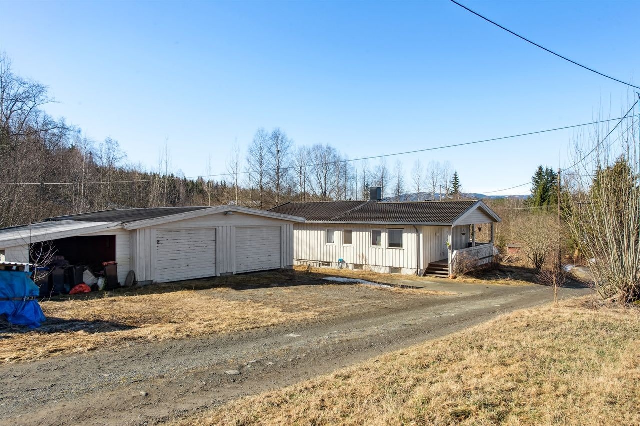 Eiendom med solrik tomt, stor garasje med carport og en praktisk enebolig Galleribilde