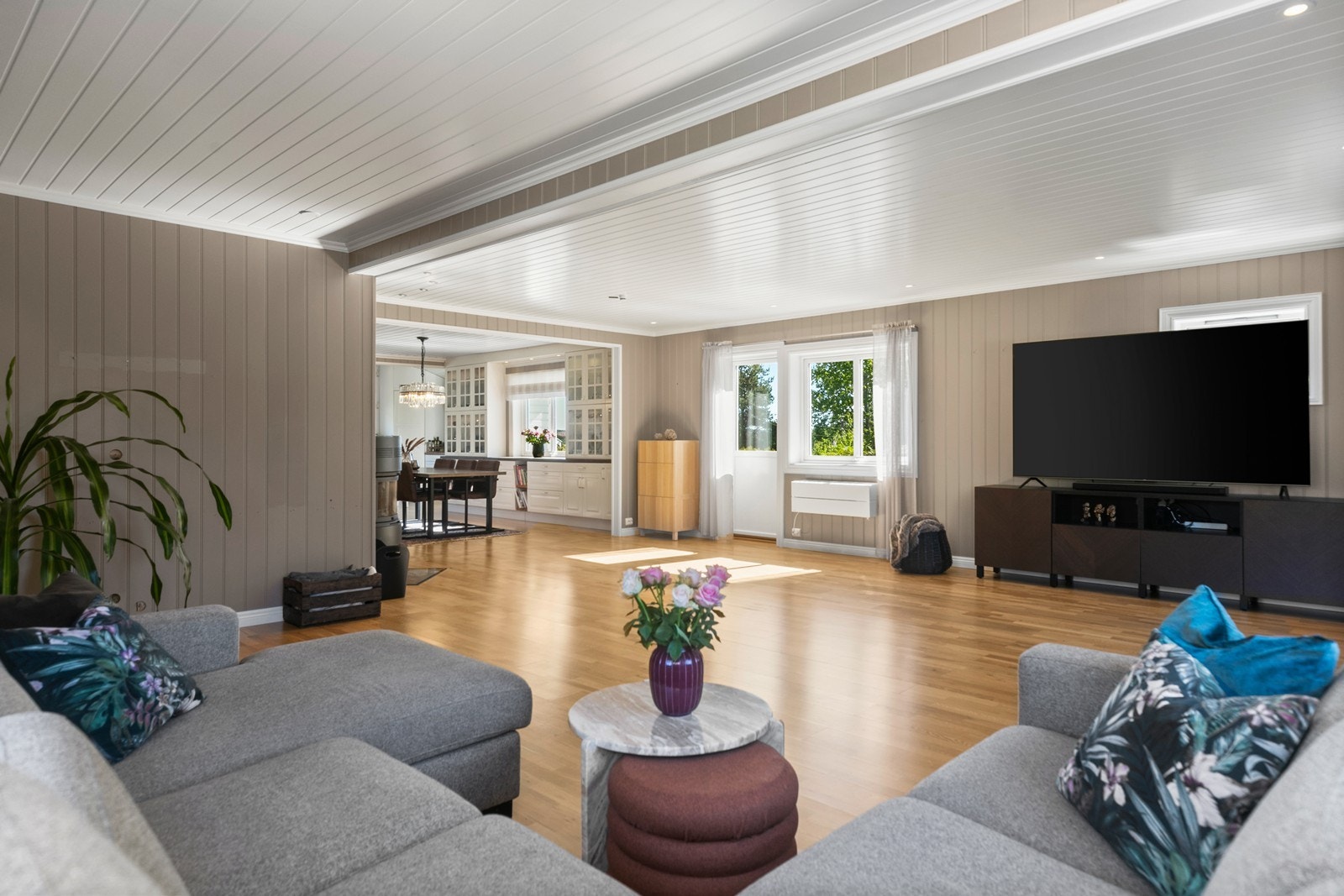 Hjertet av boligen er den åpne og lyse løsningen som binder sammen kjøkken, spiseplass og stue Galleribilde