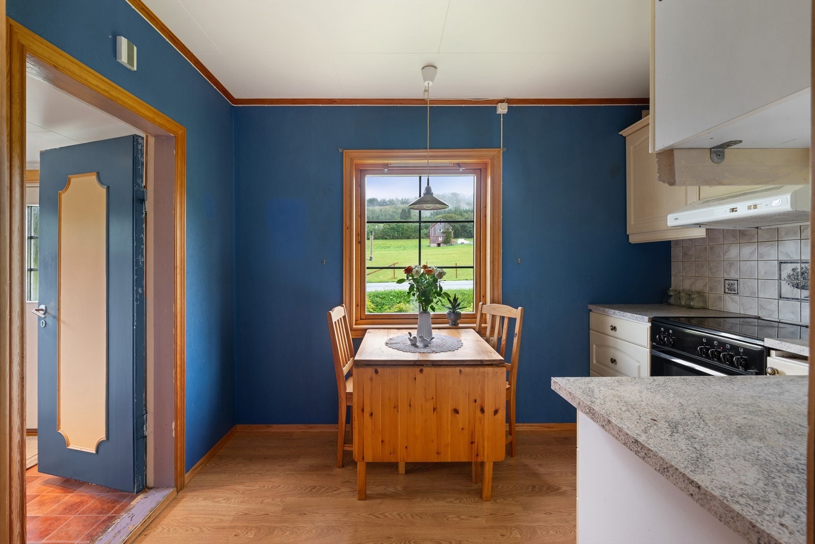 Trivelig kjøkken med plass for spisebord ved vinduet. Galleribilde