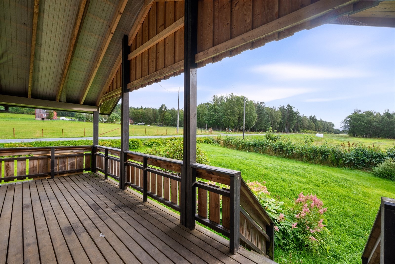 Overbygd veranda med plass for hagemøbler. Trapp ned til hagen rundt huset. Galleribilde