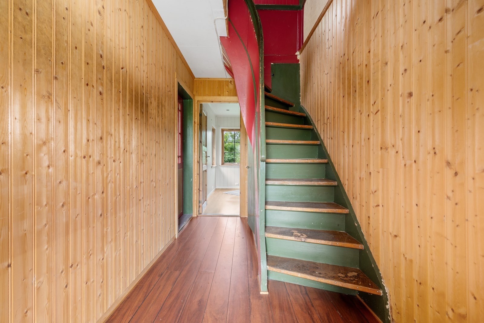 Fra gangen er det utgangsdør til området bak huset, samt til veranda og hage. Her er det også trapp opp til loftetasjen. Galleribilde