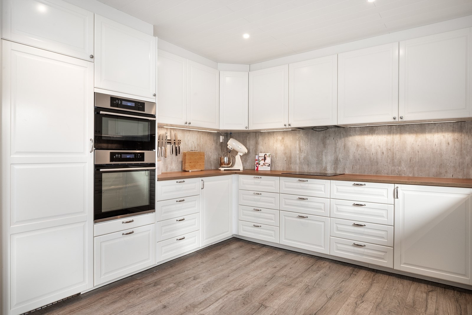 Innredning med underlimt vask og nedfelt induksjonstopp. Integrert oppvaskmaskin, stekeovn, micro og
kjøleskap medfølger i handelen. Galleribilde