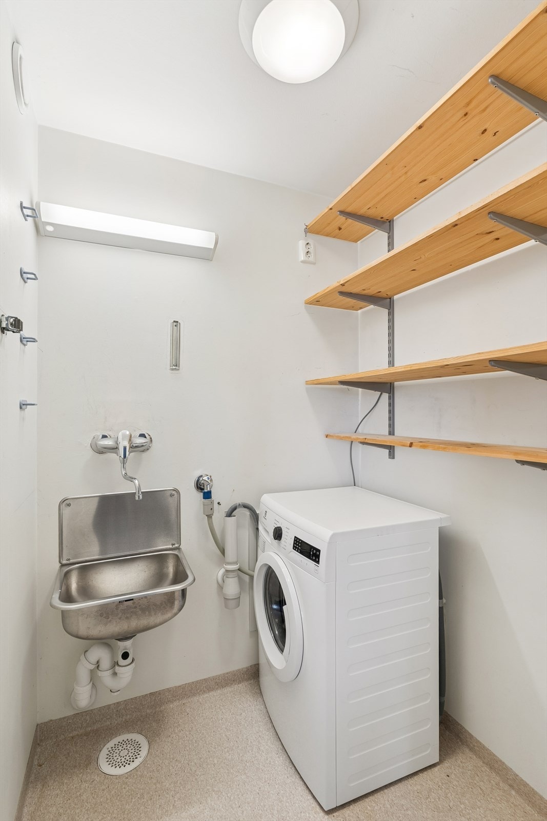 Vaskerommet har belegg på gulv, malte plater både på vegger og i himling, innredet med utslagsvask og har opplegg for vaskemaskin. Galleribilde