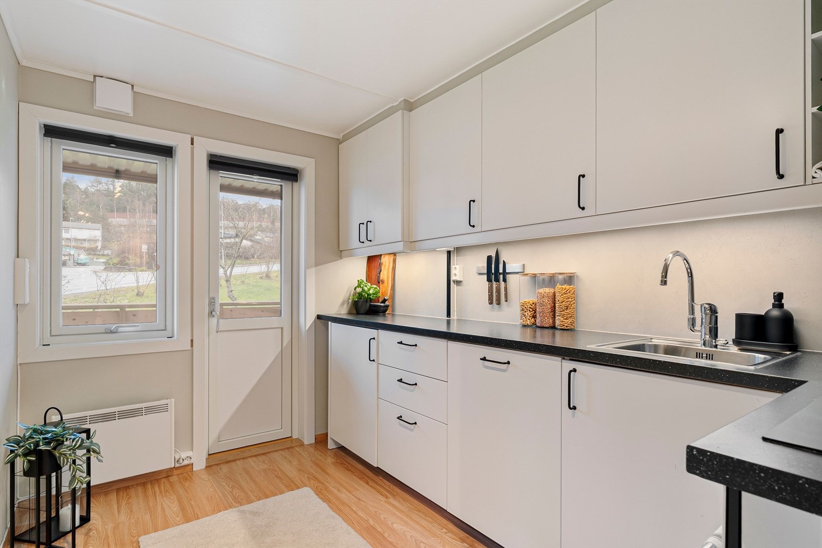 Kjøkkenet har tidløs stil med hvite fronter, og benkeplaten er i laminat, med samme farge som øvrige detaljer. Galleribilde