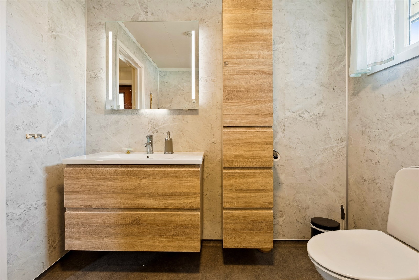 Bad i 1. etasje med våtromsplater på vegger. Gulvet har vinylbelegg med varmekabler. Galleribilde