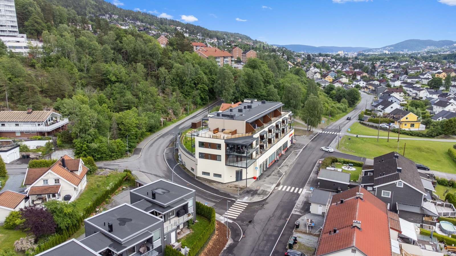 Moderne leilighetsbygg med balkonger, plassert i et grønt og rolig nabolag med god utsikt over nærområdet. Galleribilde