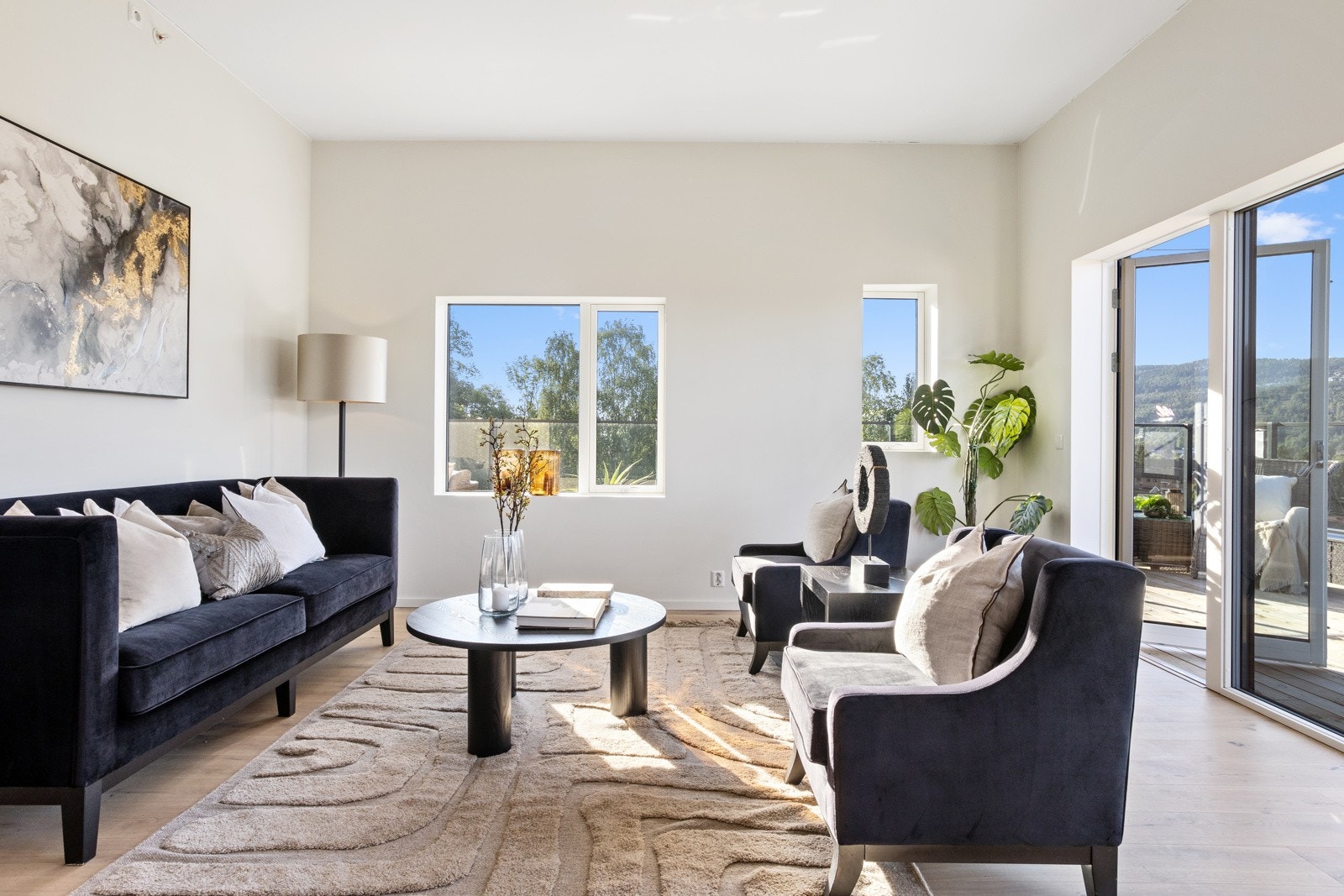 Stue med store vinduer, lysmalte vegger og utgang til balkong med utsikt. Galleribilde