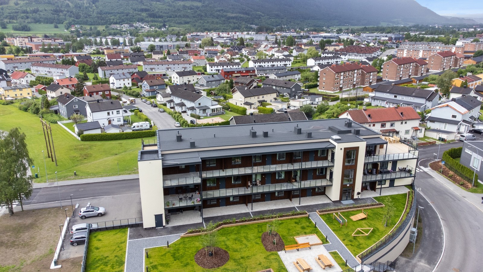 Moderne leilighetsbygg med balkonger, grøntarealer og parkeringsplasser. Utsikt over nabolaget Galleribilde