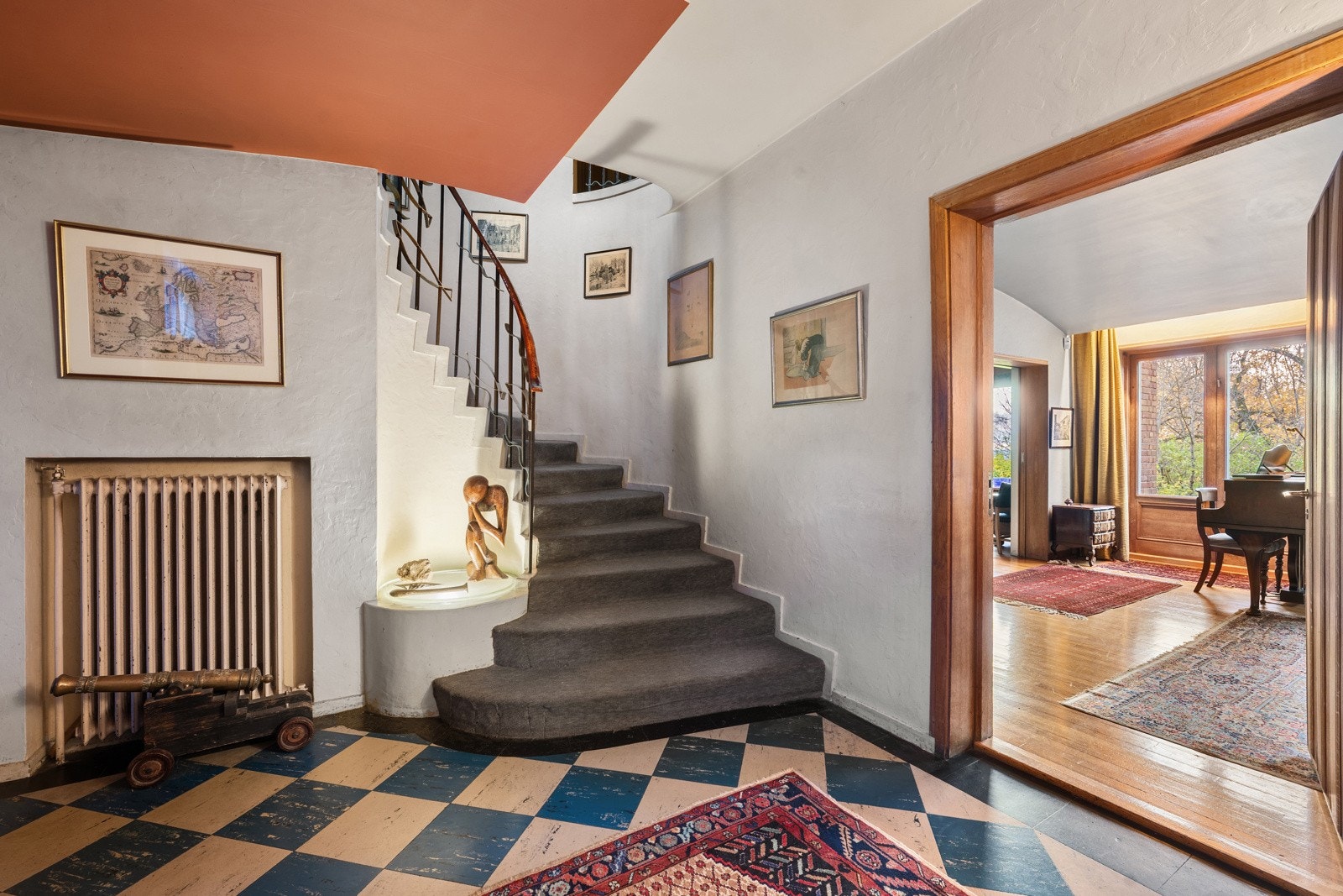 En stor og innbydende entré med flislagt gulv og lysmalte vegger.