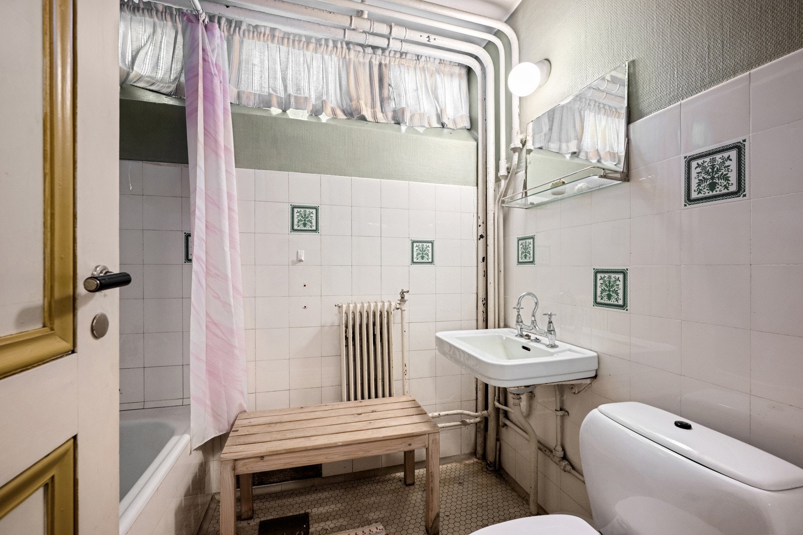 Boligens andre bad ligger i underetasjen og er innredet med badekar, servant, toalett og speil.