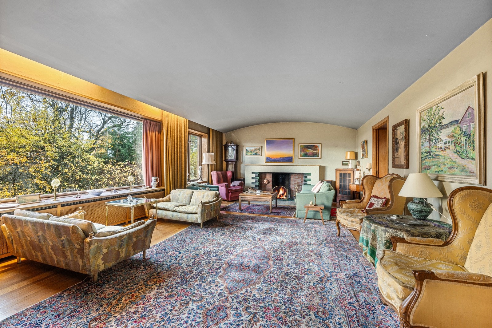 Stuen oppleves som delikat med lyse fargevalg, buet tak og store vindusflater som sørger for rikelig lysinnslipp.