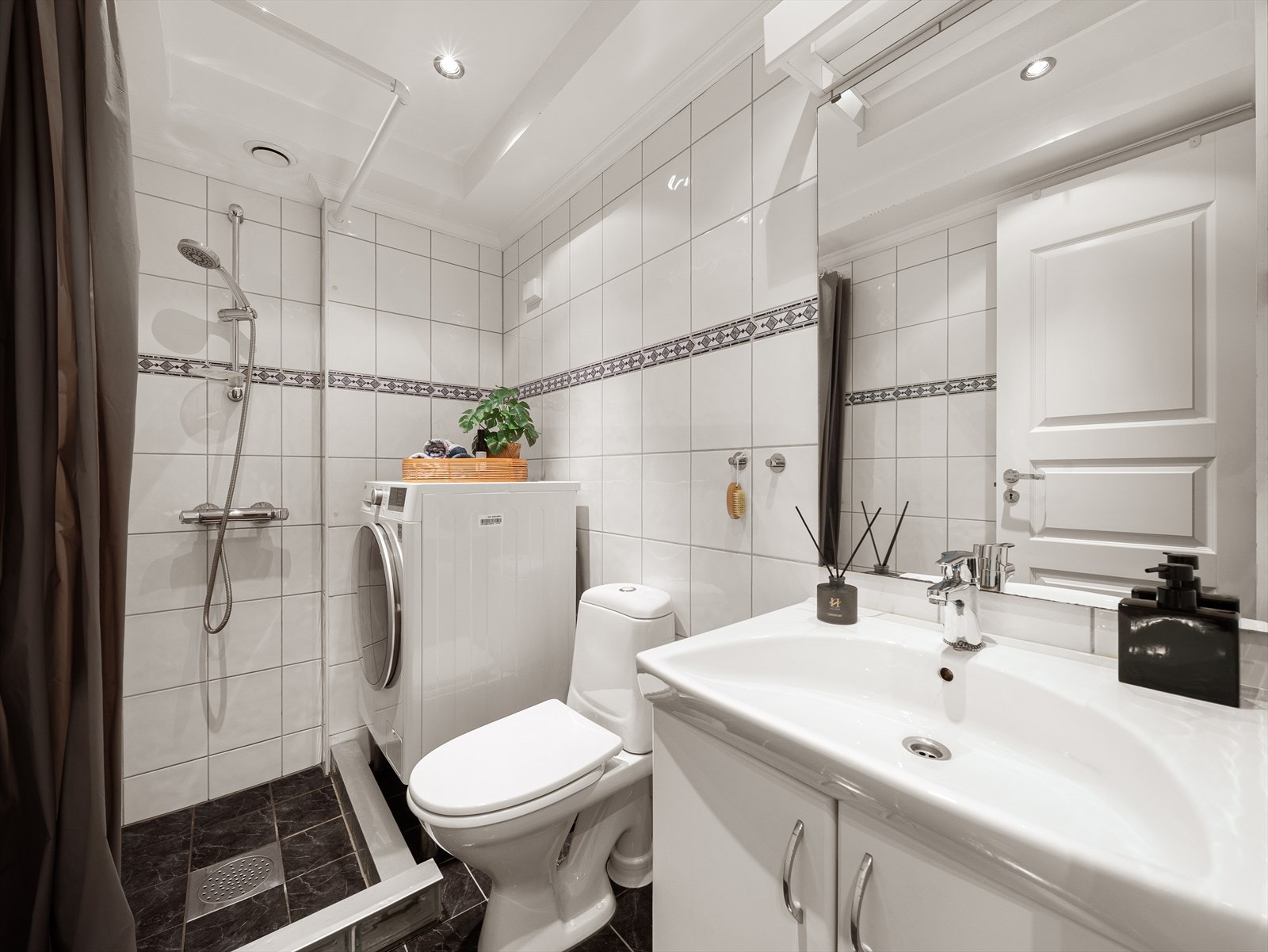 Badet ligger praktisk til i tilknytning til soverommene og er innredet med nedfelt servant, speil, toalett og dusjhjørne Galleribilde