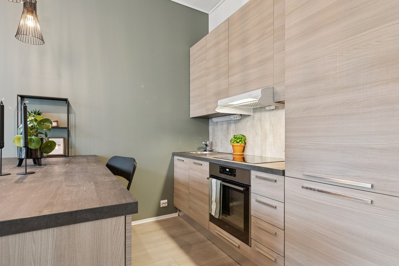 Et stilrent kjøkken med god skapplass og en funksjonell utforming som gjør matlagingen oversiktlig og enkel. Galleribilde