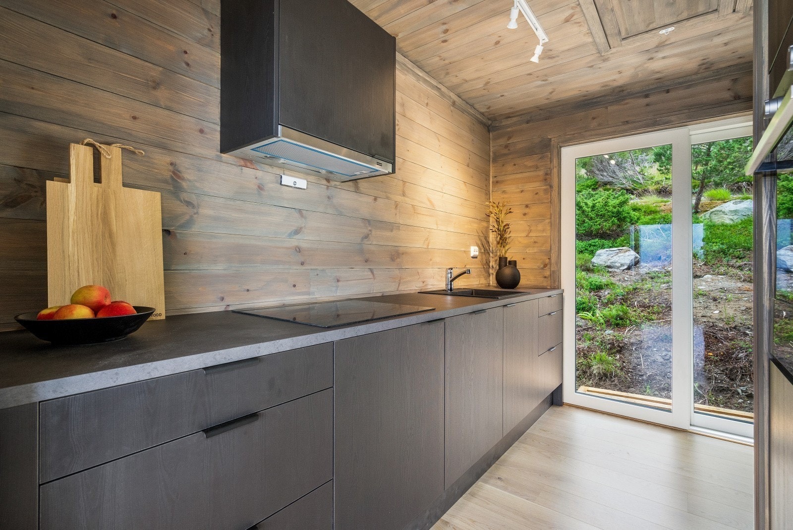 Pent og stilrent kjøkken med utgang til terrassen på den ene siden. Galleribilde