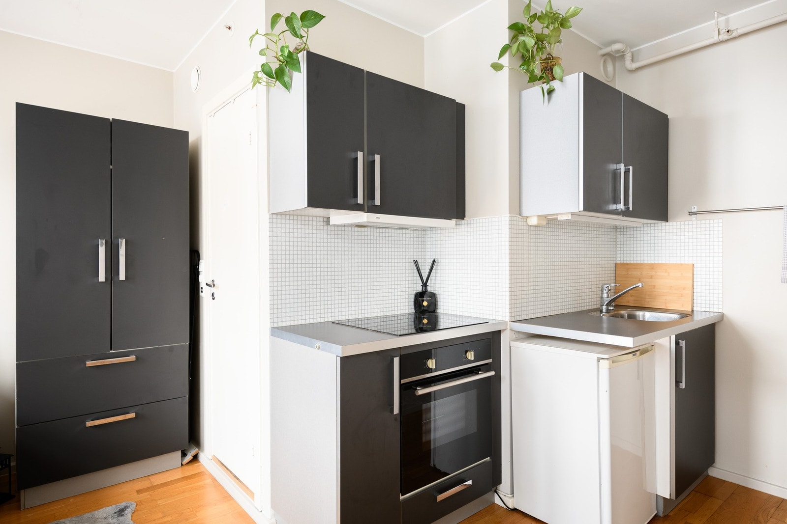 I stuen har leiligheten en praktisk, liten kjøkkenkrok med stekeovn og platetopp integrert. Galleribilde