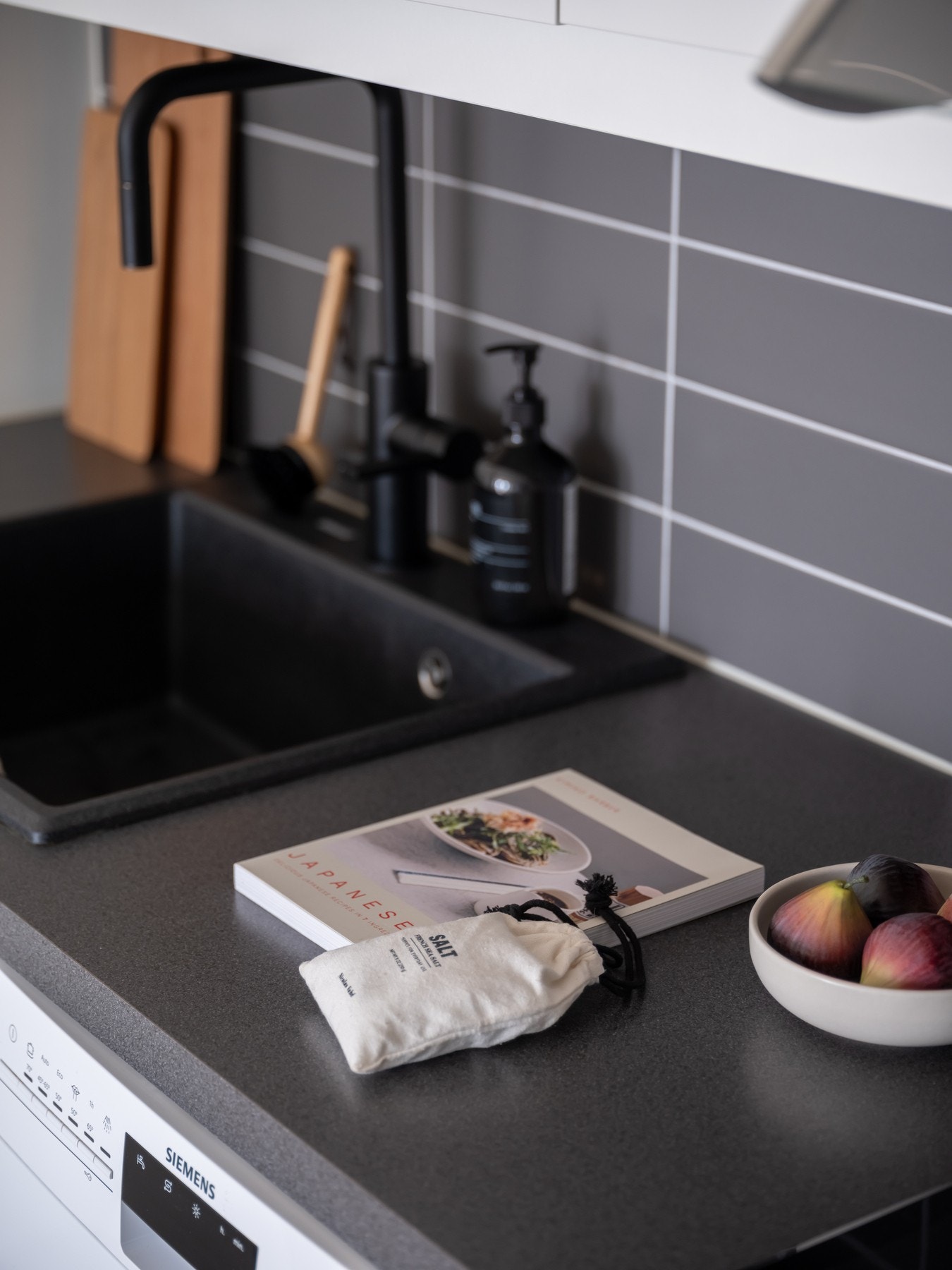 Det er flislagt over benk samt montert stikkontakt og lys under overskapene. Galleribilde