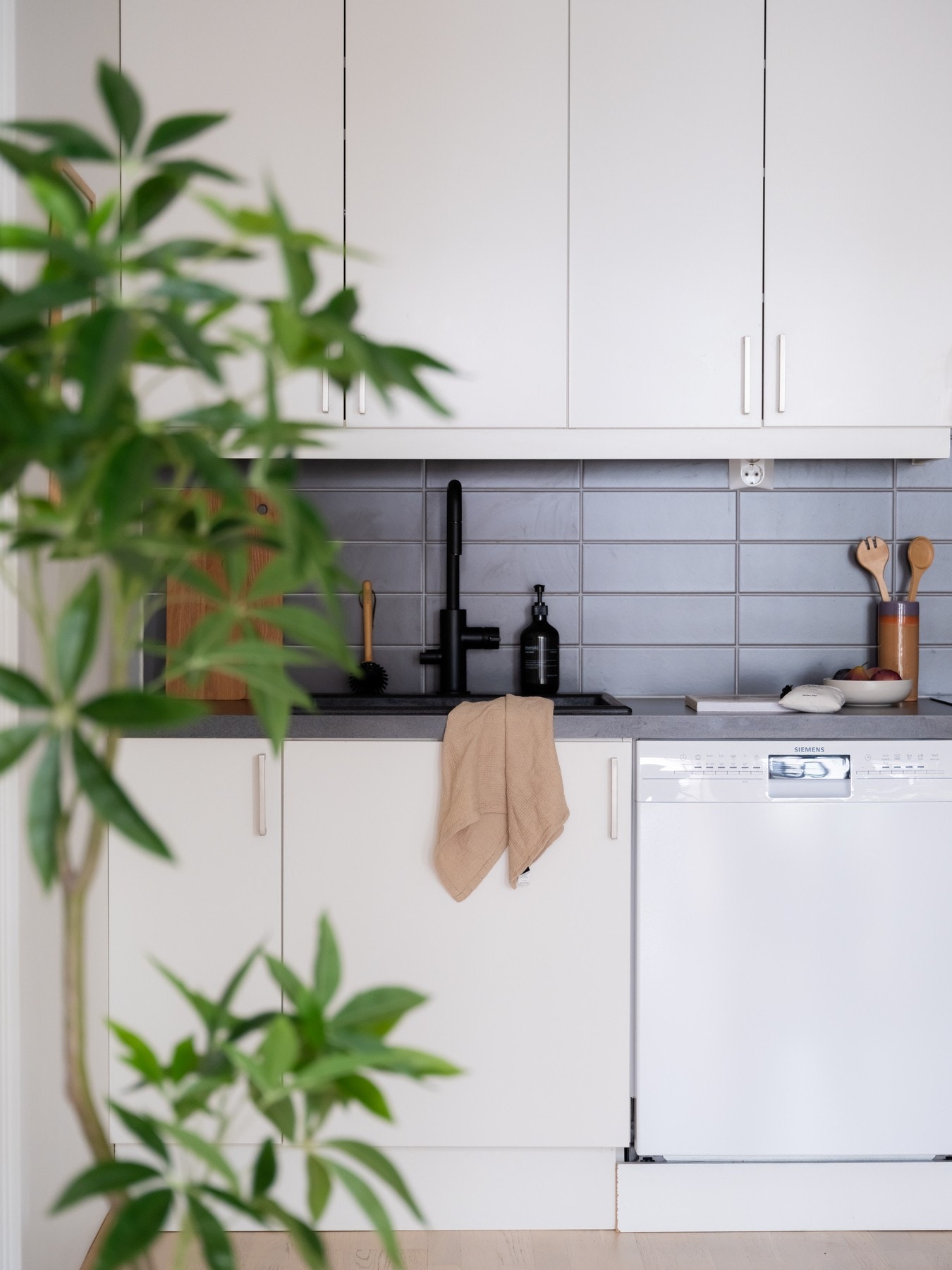 Lys, glatt innredning med laminat benkeplate og nedsenket kompositt oppvaskkum med ett-greps armatur. Galleribilde