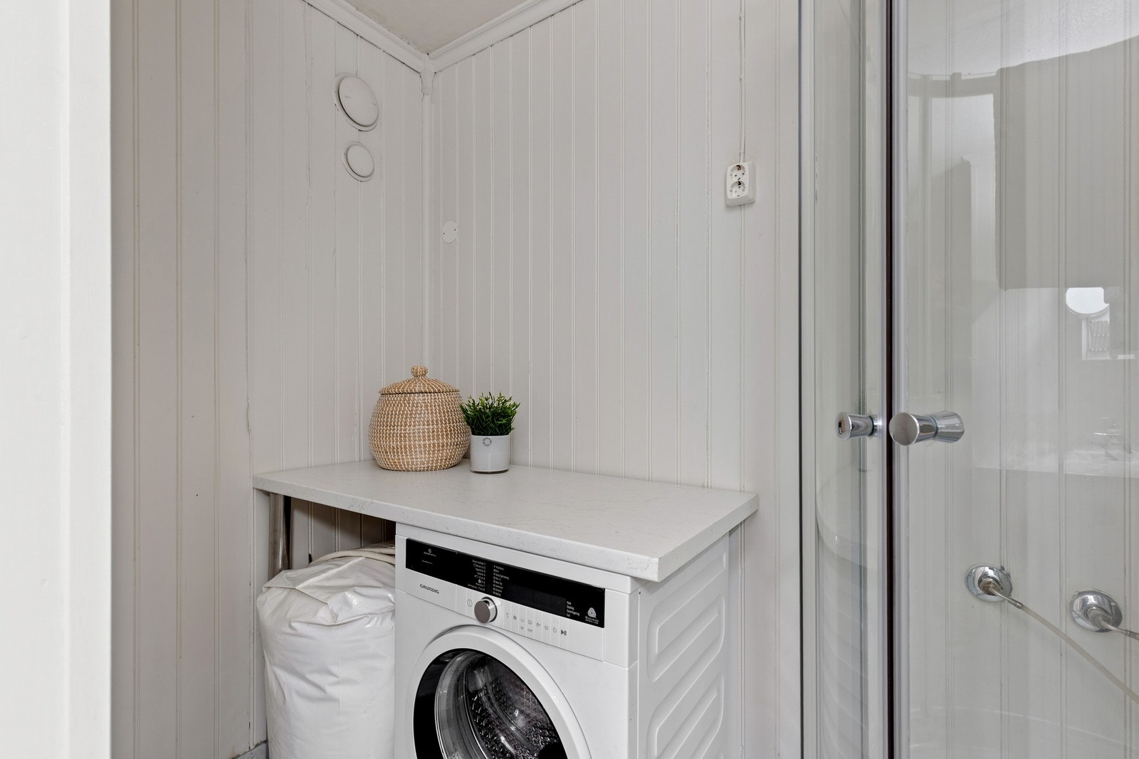 Praktisk løsning for vaskemaskin i hjørnet på badet. Galleribilde
