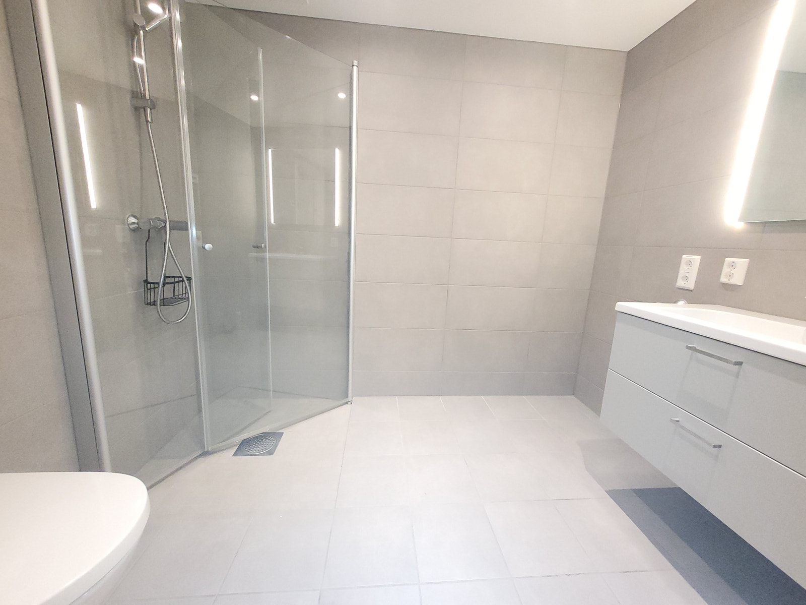 Bad med dusjhjørne og opplegg for vaskemaskin. Galleribilde