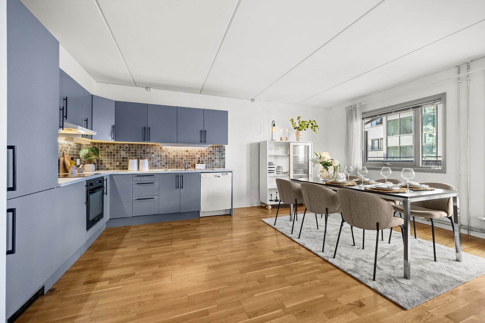 Kjøkkenet har glatte overflater med rikt med skap- og skuffeplass Galleribilde