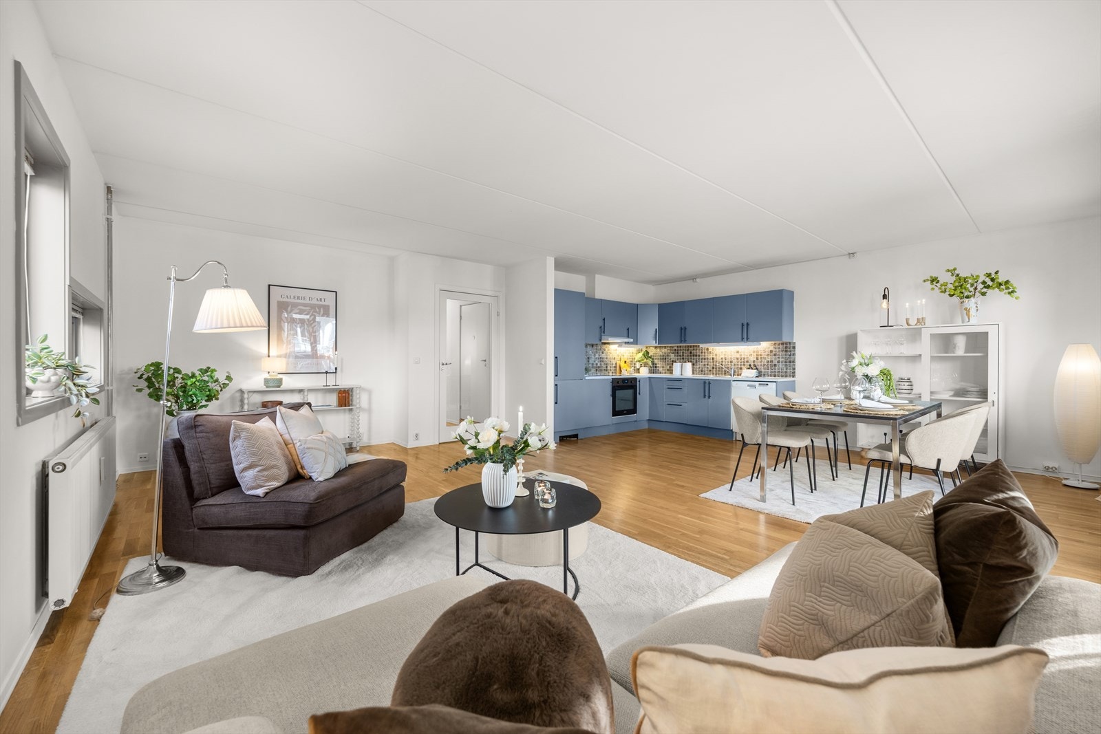 Fra hall kommer man inn til en romslig stue og kjøkken i åpen løsning Galleribilde