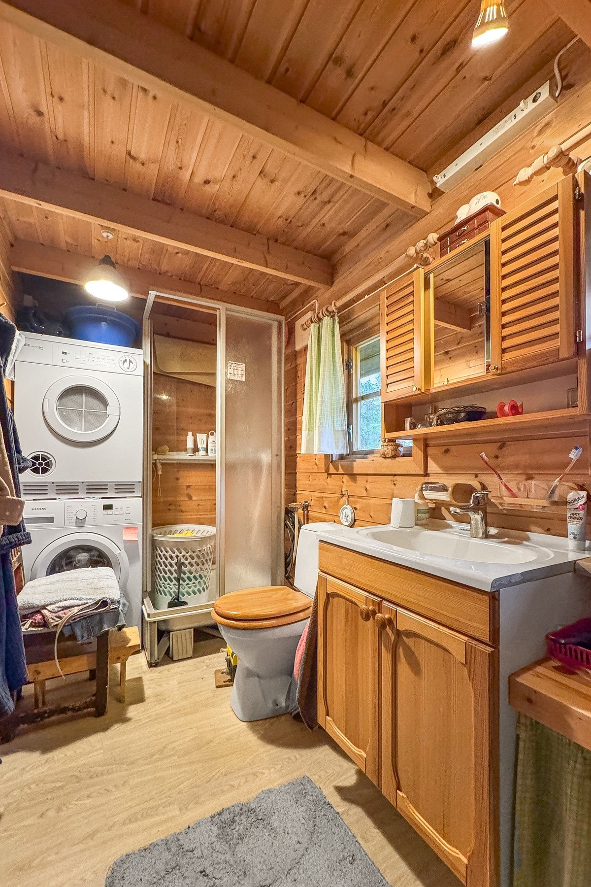 Badet er utstyrt med servantskap, toalett, dusjkabinett og opplegg for vaskemaskin Galleribilde