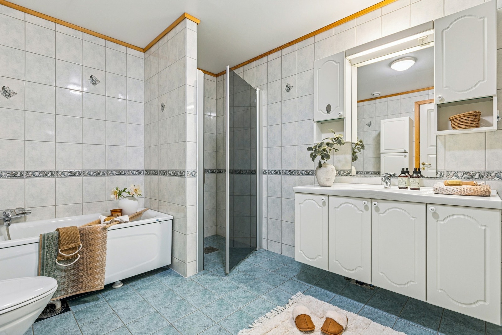 Badet er innredet med servant, servantskap, mekanisk avtrekk, opplegg for vaskemaskin, wc, dusjnisje og badekar. Galleribilde