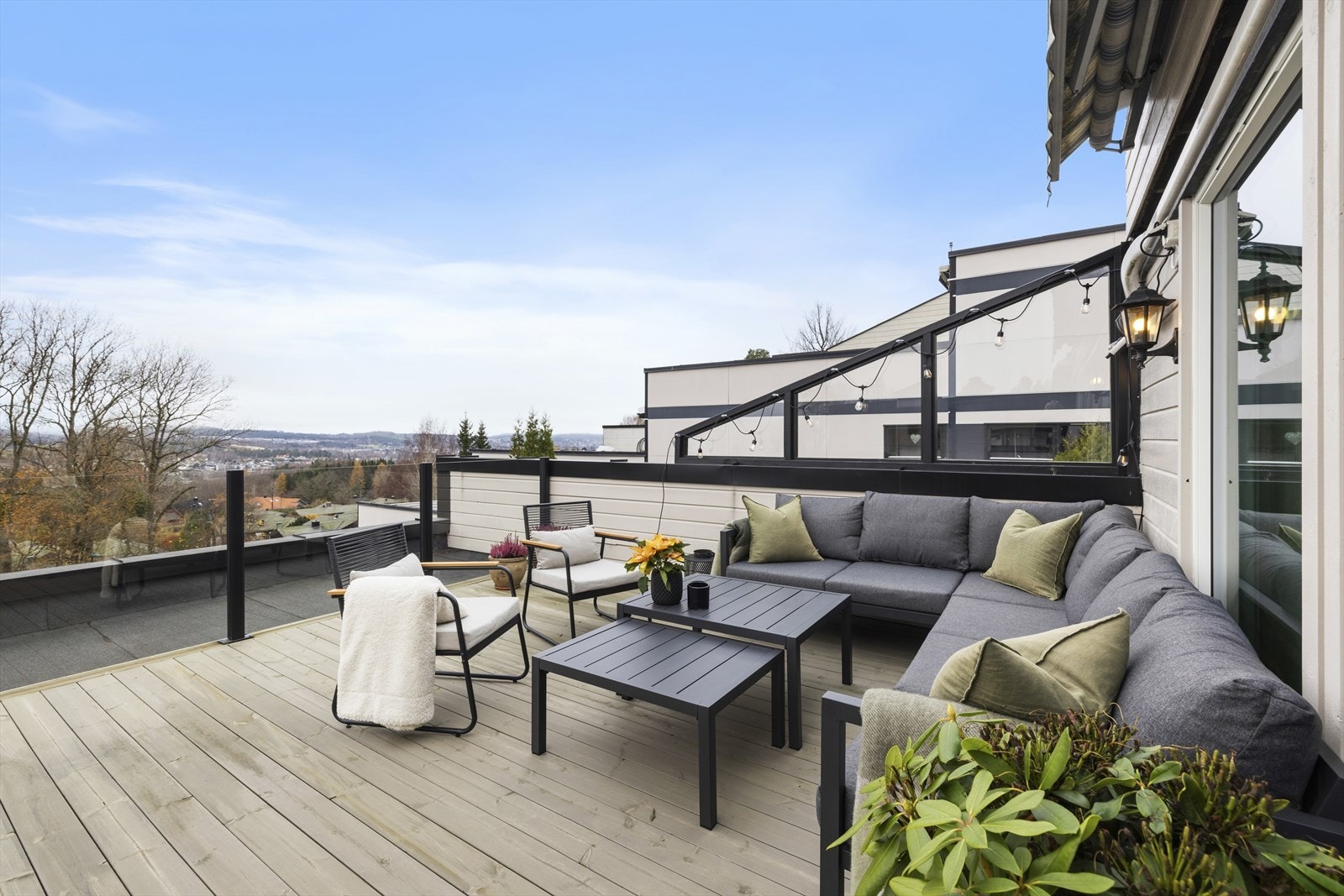 Stor, vestvendt terrasse med nytt rekkverk i glass og gulv Galleribilde