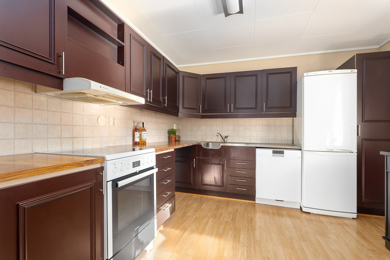 Kjøkkeninnredning med profilerte fronter og frittstående hvitevarer. Galleribilde