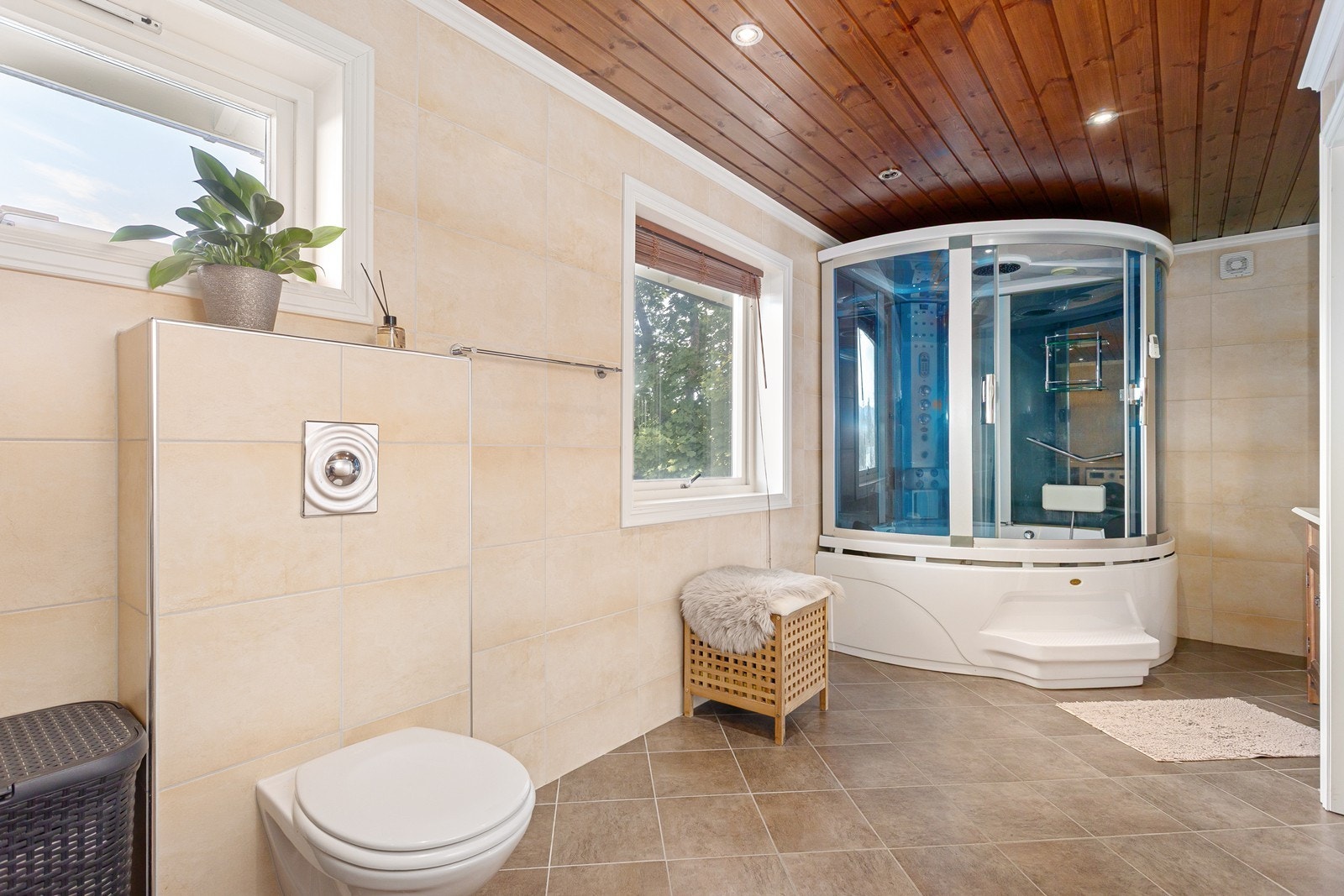 Badet inneholder servantinnredning med speil, vegghengt toalett, dusjkabinett, skyllekum og opplegg for vaskemaskin. Galleribilde