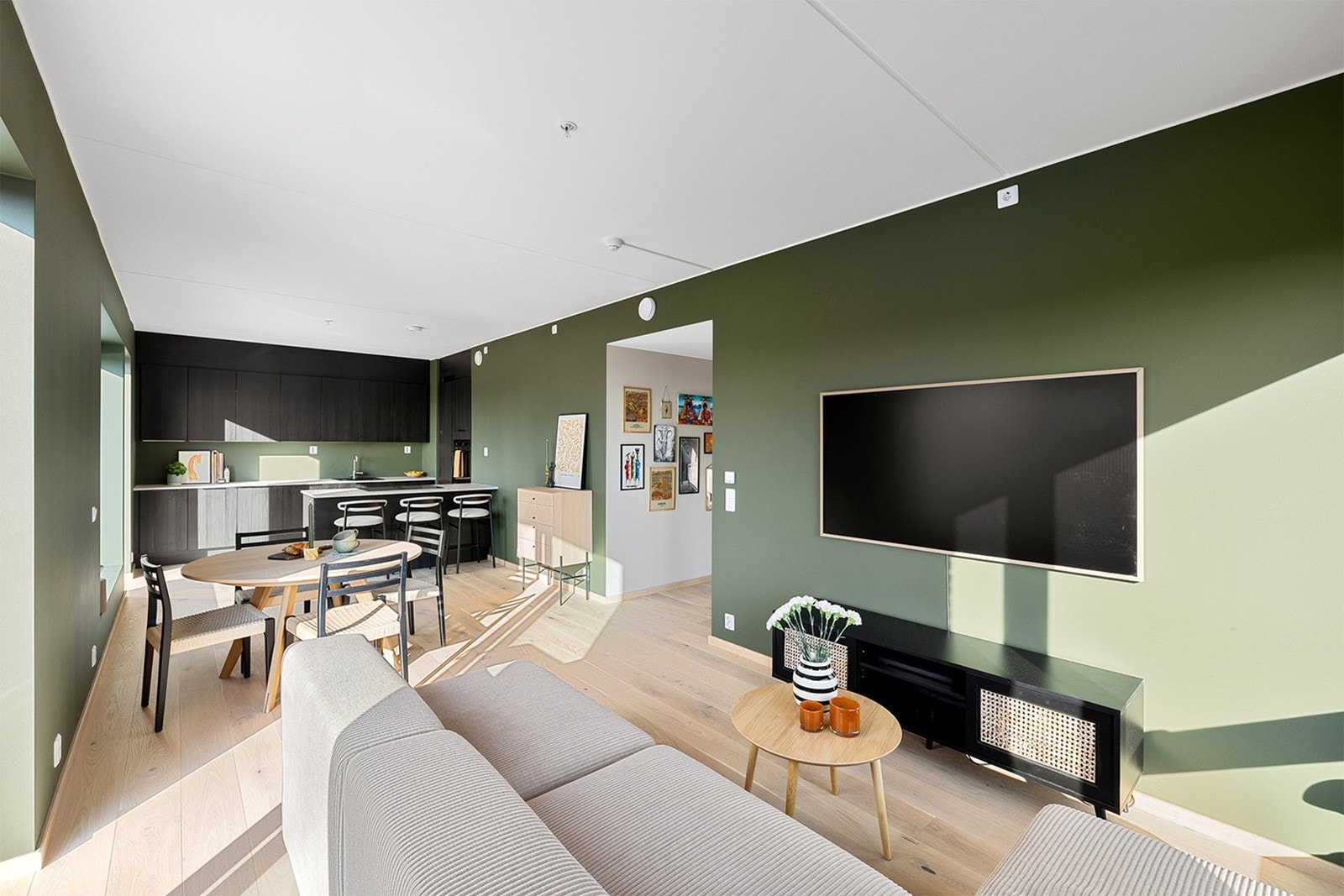 Leiligheten har en moderne og åpen stue- og kjøkkenløsning som skaper en luftig og sosial atmosfære. Galleribilde