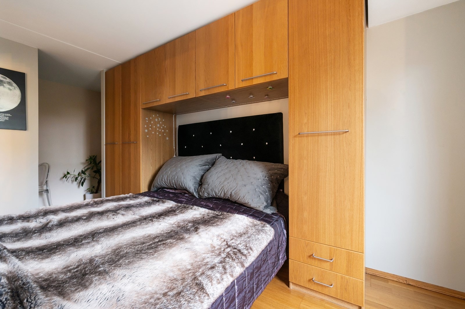 Smarte, plassbygde garderobeskap rammer sengen inn på en elegant og funksjonell måte. Galleribilde