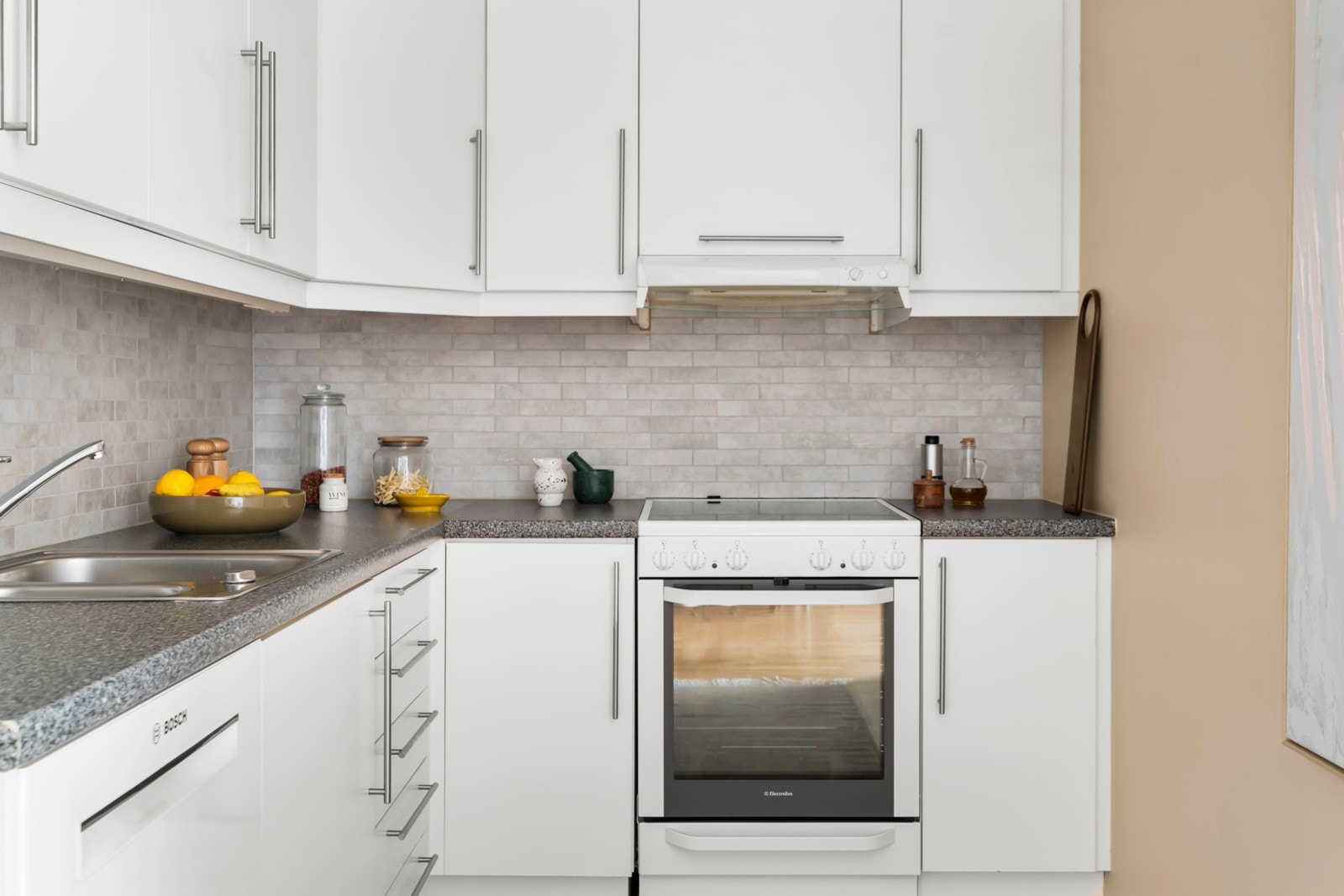 Innredningen består av hvite, slette fronter og overskap. Slitesterk benkeplate i laminat Galleribilde