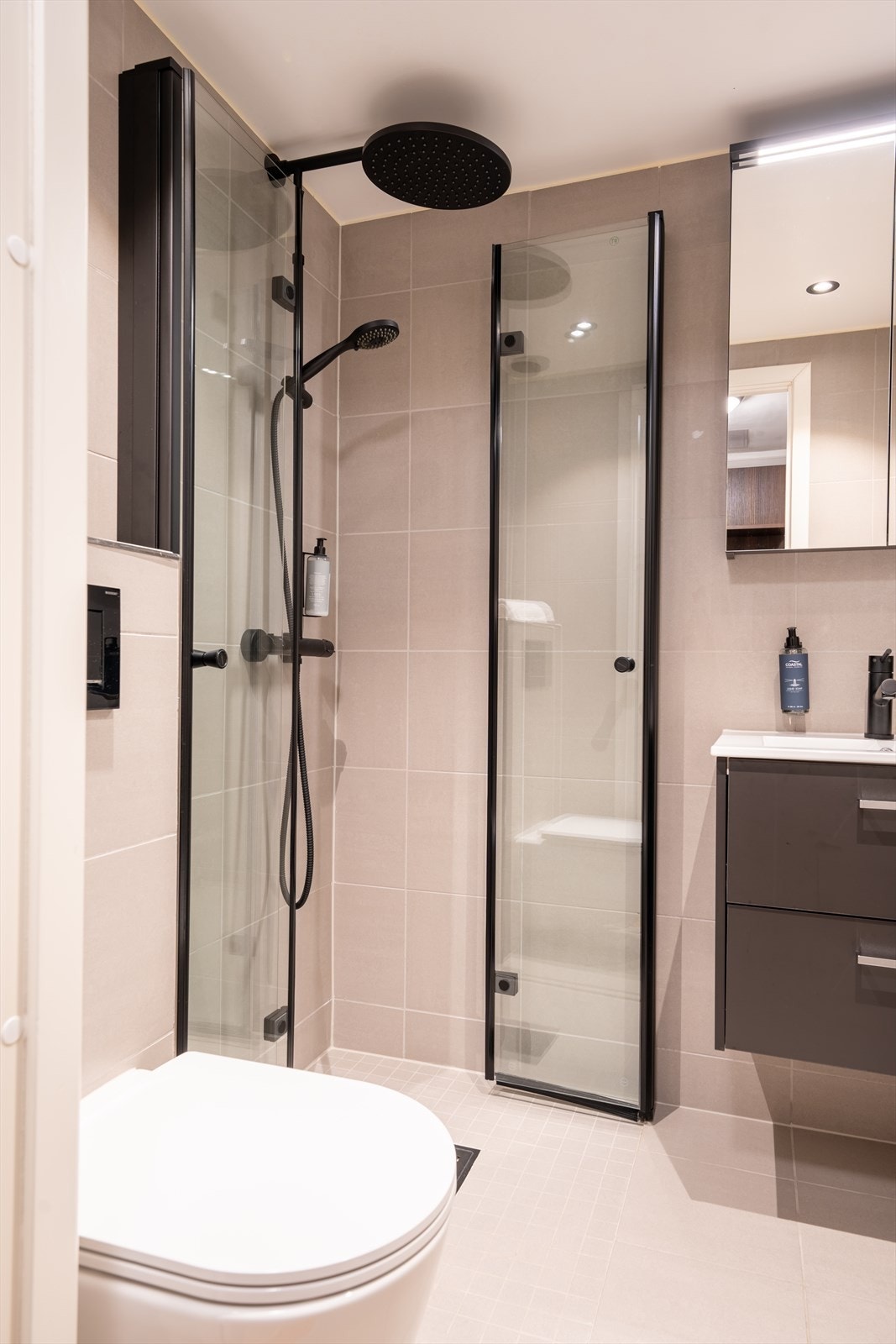 Bad med vegghengt toalett og dusj med glassvegger/dører Galleribilde